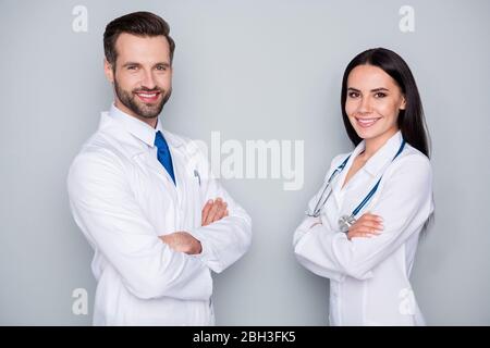 Photo of handsome doc guy professional lady patient consultation virology clinic listen client toothy smiling arms crossed experienced doctors wear Stock Photo