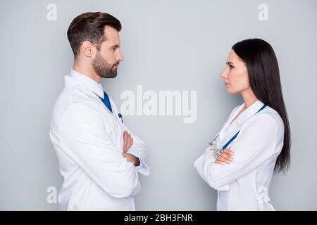 Who is best. Profile photo of family doc lady professional guy arms crossed one promotion place look eyes stand opposite competition wear white lab Stock Photo
