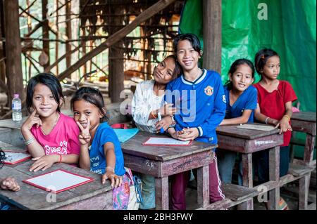 Cambodian school children smile for the camera in a school in the Kampong Phluk (floating) village, Siem Reap Province, Cambodia. Stock Photo