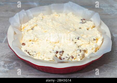 raw cottage cheese casserole dough in a round ceramic baking dish Stock Photo