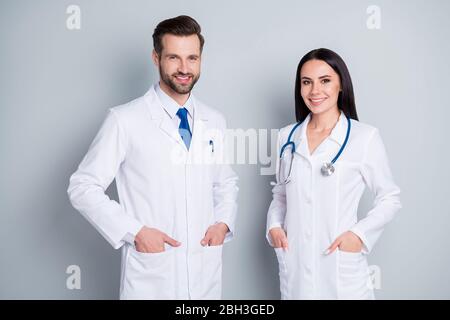 Photo of handsome doc guy practitioner experienced professional pretty lady two people patients consultation virology clinic good mood wear lab coats Stock Photo