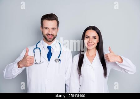 Photo of handsome doc guy lady two people emergency patient consultation virology clinic thumbs up approve health condition experienced doctors wear Stock Photo