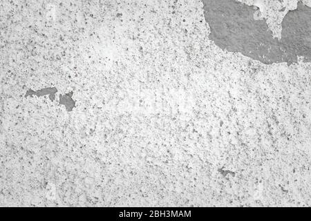 Weathered white wall. Peeling paint shows concrete underneath. Detail close up. Stock Photo