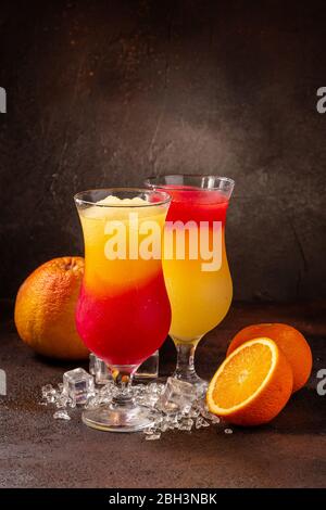 Delicious icy cocktail with fruits on dark grounge background. Healthy colorfull fruit shakes with ice on textured table. Stock Photo