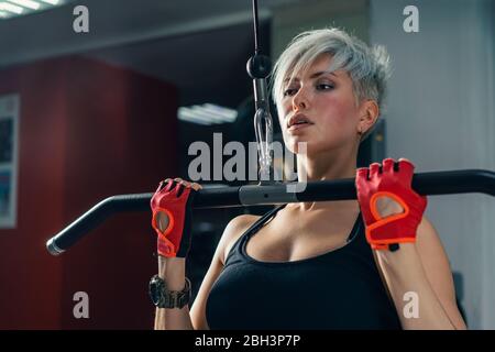 beautiful muscular fit woman exercising building muscles Stock Photo