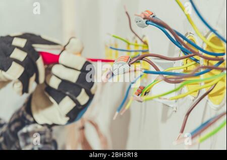 Close Up Of Electrician Assembling And Connecting Wires For Electrical Plugs. Stock Photo