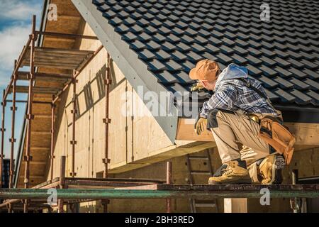Roof Contractor Inspects Progress In New House Construction And Roof Installation. Stock Photo