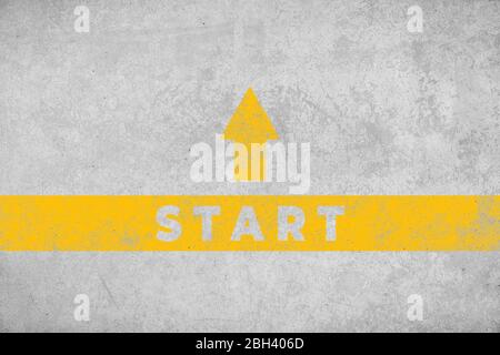 Start concept. Aged concrete floor with yellow painted arrow and text Stock Photo