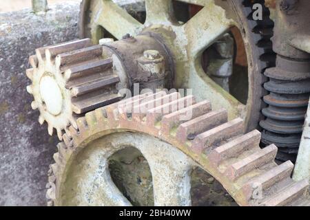 The cogs of large moving old metal gears fit together in this machinery Stock Photo