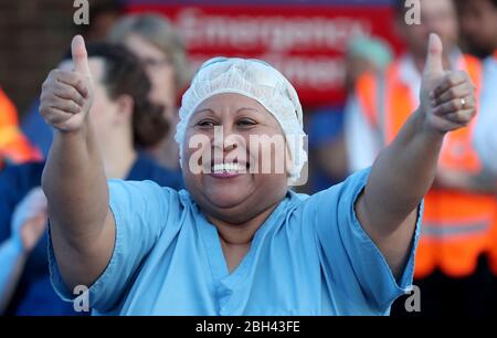 Doctors, nurses and NHS staff outside the William Harvey Hospital, in Ashford, Kent, to salute local heroes during Thursday's nationwide Clap for Carers initiative to recognise and support NHS workers and carers fighting the coronavirus pandemic. Stock Photo