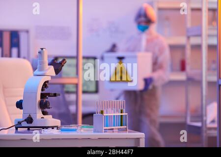 Image of medical equipment and test tubes on the table with scientist working in the background at the laboratory Stock Photo