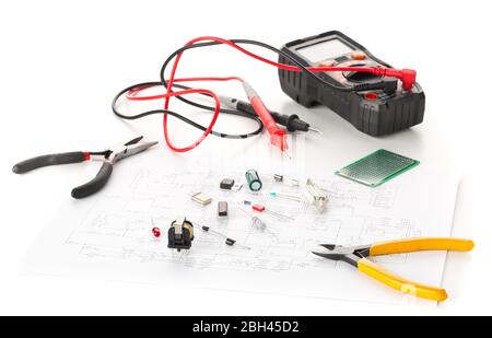 Different electronic parts or components, measurement tool and pliers on white background with pcb wiring diagram, resistors, capacitors, diode and ic Stock Photo