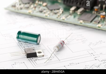 Transistor, resistor and capacitor electronic parts or components in front of pcb board with pcb wiring diagram - electronic device repair concept, se Stock Photo