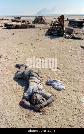 The body of an Iraqi soldier lays dead in the desert among destroyed vehicles and military equipment near Highway 80 following the coalition invasion to liberate Kuwait at Mutla Ridge April 8, 1991 near Al Jahra, Kuwait. The road became known as the highway of death after American and Canadian aircraft destroyed more than 1,400 vehicles killing hundreds of fleeing Iraqi soldiers. Stock Photo