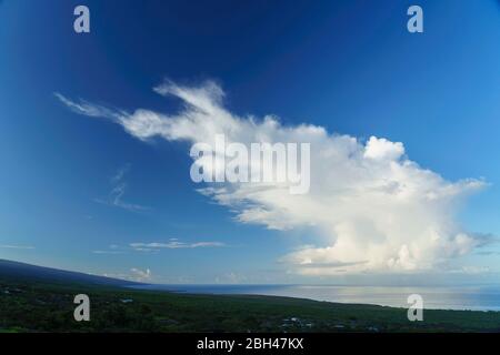 Cumulus Cloud  looking along South Kona Coast in Hawaii with Mauna Loa rising from the sea on left . Stock Photo