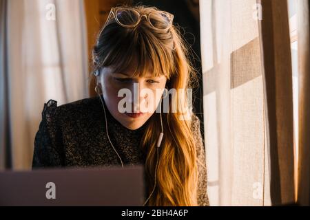 Businesswoman working on laptop computer taking notes and running her business from home during the covid-19 stay at home order.  Covid-19 pandemic Stock Photo
