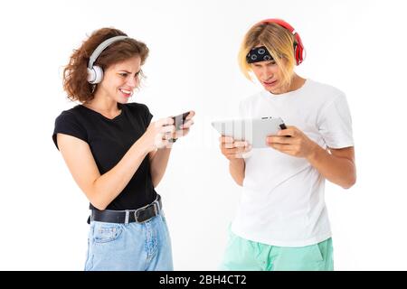 Stylish caucasian blonde man and young woman texting and listen to music isolated on white background. Stock Photo