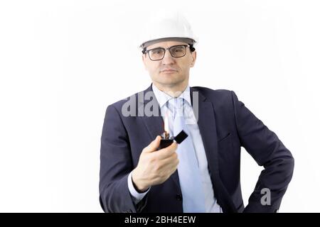 thoughtful focused on handsome engineer in white helmet holds burning lighter Stock Photo