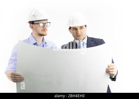 Two positive engineers look at drawing, boss gives instructions to subordinate Stock Photo