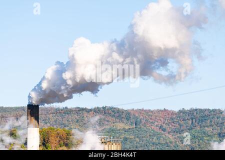 Covington, Virginia city in Alleghany county small town and pollution from paper mill smokestack closeup against sky Stock Photo
