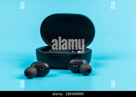 Wireless bluetooth headphones isolated on blue background Stock Photo
