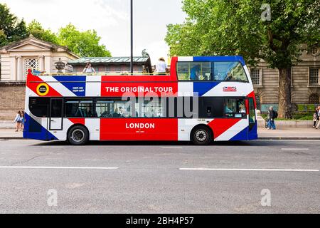 London, UK - June 21, 2018: Buckingham Palace and sign for Hop on Hop off The Original Tour double decker red white blue bus with people walking Stock Photo