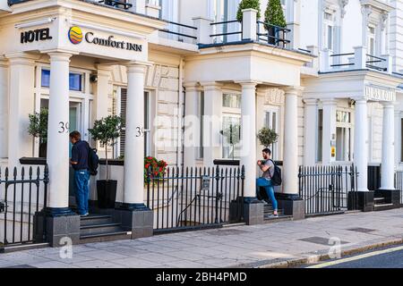 London, UK - June 22, 2018: Belgrave street road in downtown city with Comfort Inn hotel motel sign, people in Westminster area with sidewalk white fa Stock Photo