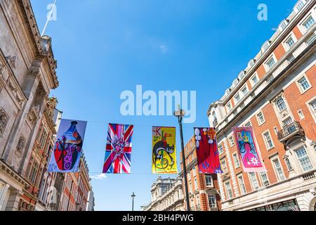 London, UK - June 22, 2018: Piccadilly circus street road with royal academy of arts exhibit banners against blue sky and historic architecture on sun Stock Photo