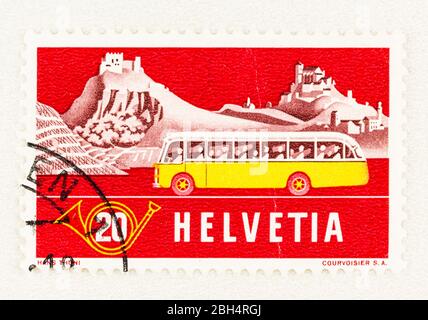 SEATTLE WASHINGTON - April 18, 2020:  Red Swiss postage stamp with summer view of Alpine Post Bus, damaged with crease.  Scott # 346 Stock Photo