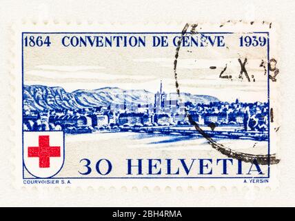 SEATTLE WASHINGTON - April 18, 2020:  Blue Swiss postage stamp with view of Geneva, commemorating 75th anniversary of International Red Cross Society. Stock Photo