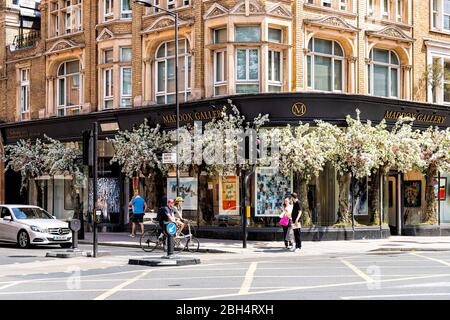 London, UK - June 24, 2018: Notting Hill area with sign for Maddox Gallery on Westbourne Grove road street and historic architecture with people shopp Stock Photo