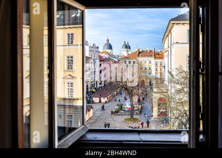 Lviv, Ukraine - January 21, 2020: Above view of historic Ukrainian city in old town market rynok square with stores and people walking in winter on su Stock Photo