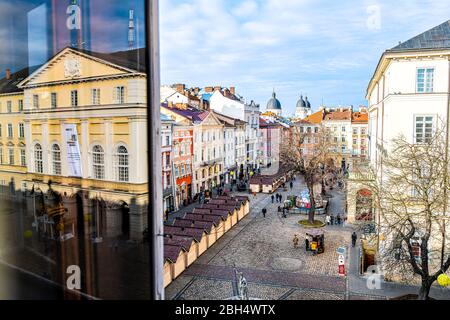 Lviv, Ukraine - January 21, 2020: View of historic Ukrainian city in old town market rynok square with stores and people walking in winter on sunny da Stock Photo