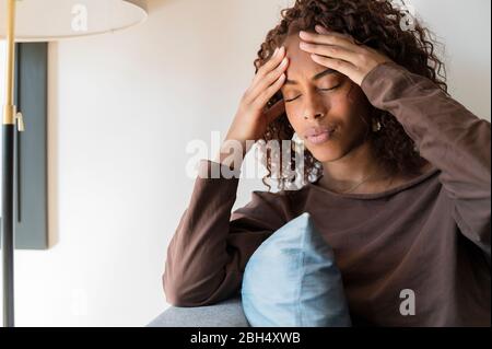 Woman with headache holding her head Stock Photo
