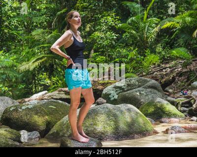 Woman standing on rock in forest Stock Photo
