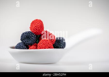 Gummy candies in white bowl isolated on white background Stock Photo