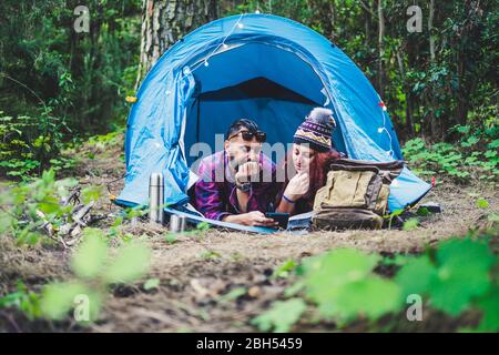 Couple lying in tent using tablet Stock Photo