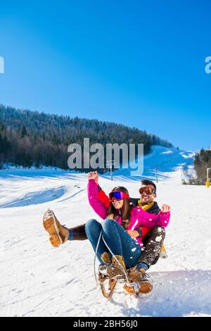 Young Happy Couple On Sledge Having Fun Stock Photo