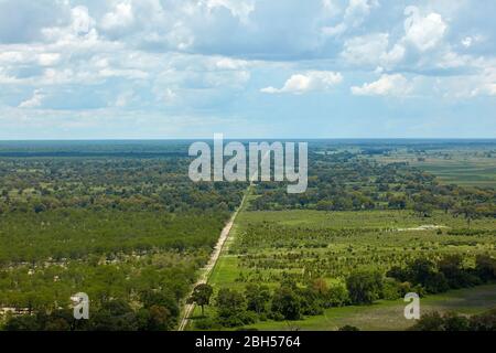 Buffalo fence (veterinary disease control fence) separating wildlife from domestic cattle, and Boro River, Okavango Delta, Botswana, Africa- aerial Stock Photo