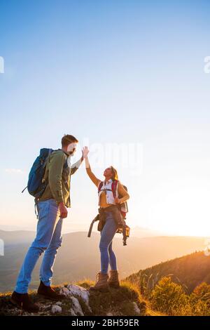 Couple on Top of a Mountain Shaking Raised Hands Stock Photo
