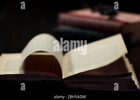 Book turning pages with magic spell sorcery. Paranormal concept open book mysteriously flipping pages. Antique library of a witch or sorcerer. Stock Photo