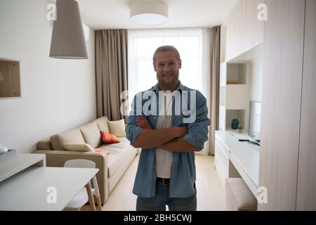 Portrait of young man in modern studio apartment look at camera. Stock Photo