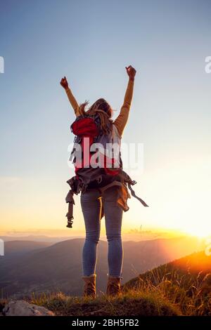 cheering woman open arms at sunrise mountain peak Stock Photo - Alamy