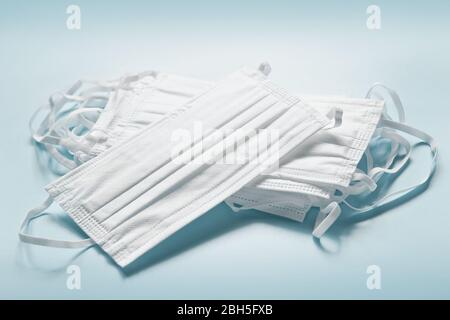 White safety face masks pile on blue background. Coronavirus, flu, air pollution filter. Personal protective equipment supplies Stock Photo