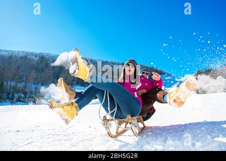 Young happy couple sledding in winter at ski center Stock Photo