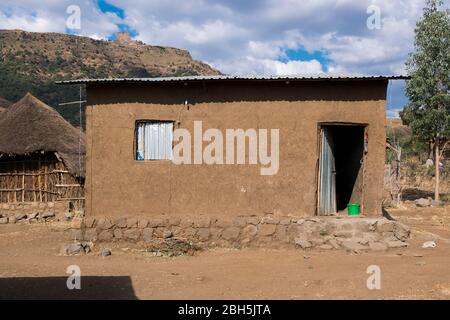 A typical thatch, stick, mud, stucco-covered, tin corrogated roof house in rural Ethiopia, Africa. Stock Photo