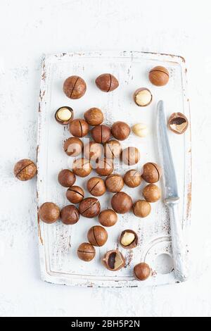 Plate with almonds in endocarp, whole and chopped open nuts in bulk on a cutting board Stock Photo