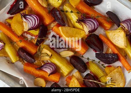 Colorful roasted vegetables on tray with parchment. Mix of carrots, beets, turnips Stock Photo