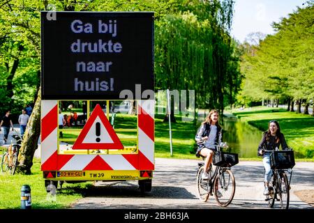 Rotterdam, Netherlands. 23rd Apr, 2020. ROTTERDAM - stay home says the sign Crowds in a park because of the nice weather ROBIN UTRECHT stay at home no groups keep 1.5 meters away matrix signsThe Dutch government ordered closure of public facilities and advised people to stay home in an attempt to control the spread of the COVID-19 Coronavirus. Credit: SOPA Images Limited/Alamy Live News Stock Photo