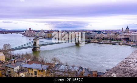 View of Chain Bridge, Hungarian Parliament and River Danube form Castle Garden Bazaar, Budapest Hungary. Image in shades of purple. Stock Photo